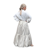 Modelo usando vestido maxi Dani Levine champagne com corpete estilo camisa e saia em camadas brilhante em Paris