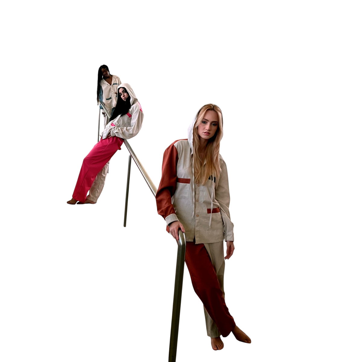 Modelos vestindo Dani Levine Metropolitan New York PJs unissex com capuz e design color-block em corredor moderno.