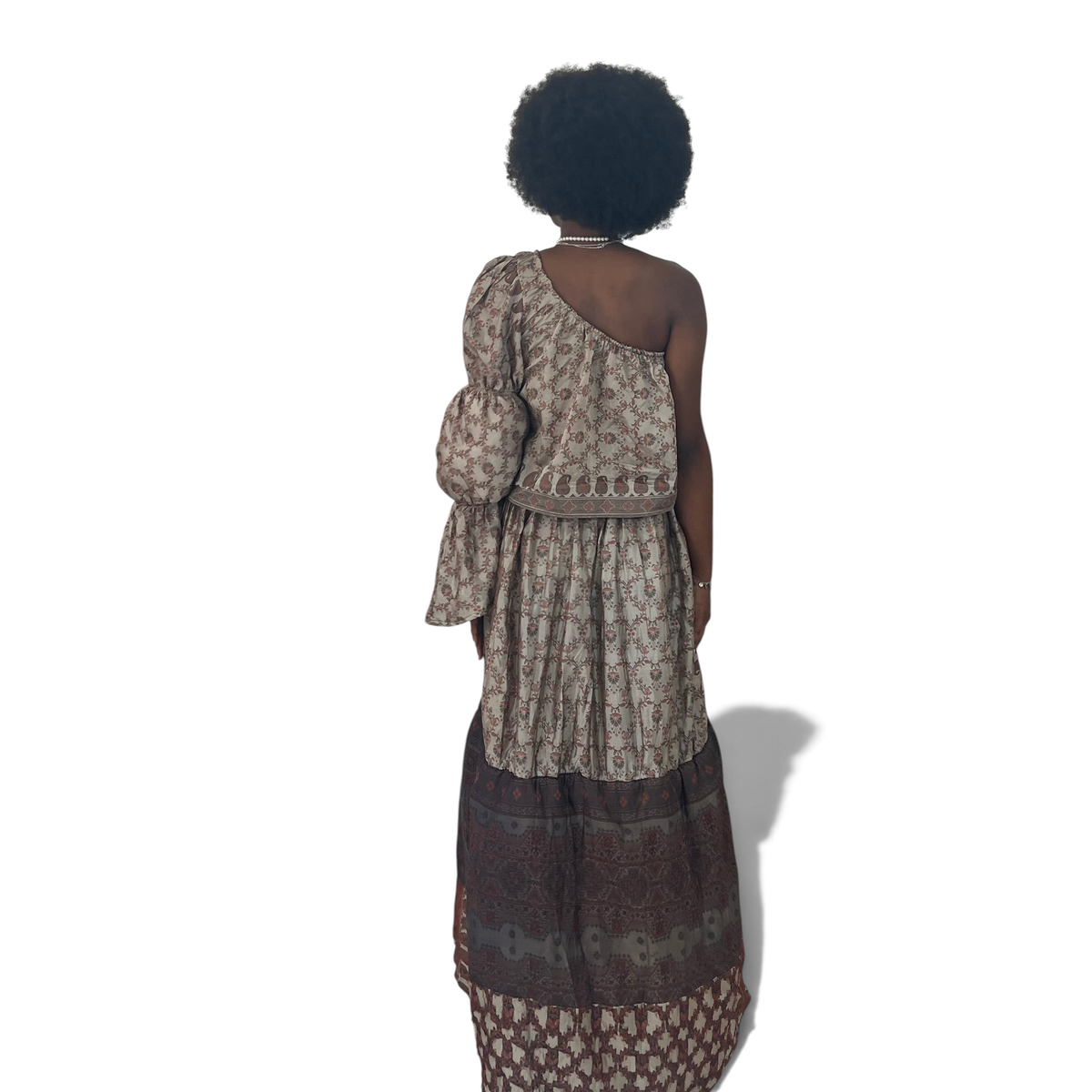 Vestido longo Dani Levine Heritage Earth com um ombro só, manga bufante e estampa botânica em tons terrosos.