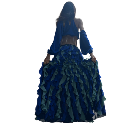 Conjunto Dani Levine Jardin Bleu com top drapeado azul real e saia longa de babados em tons de azul e sálvia ao ar livre
