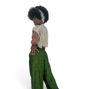 Modelo veste conjunto Dani Levine Savanna Emerald com calça verde de pernas largas e blusa estampada com faixa