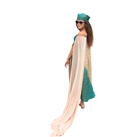 Modelo usando vestido Dani Levine Trancoso de linho e seda com capa transparente, tons dourados e detalhes turquesa.