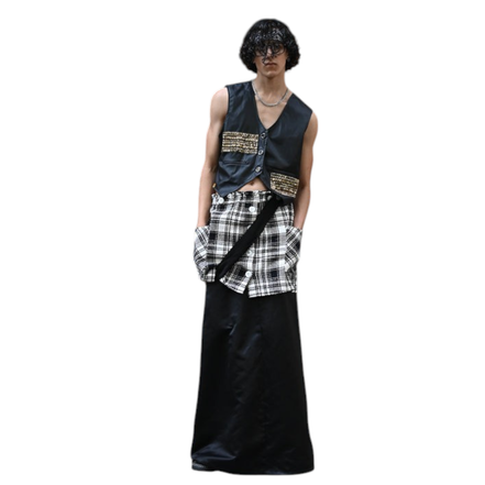 Modelo vestindo conjunto Dani Levine com colete preto, detalhes dourados, camada de tweed e saia longa preta.
