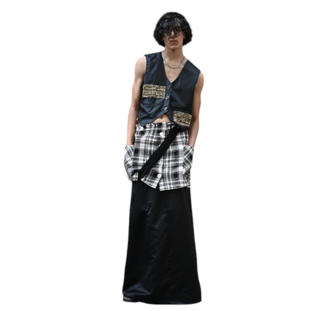 Modelo vestindo conjunto Dani Levine com colete preto, detalhes dourados, camada de tweed e saia longa preta.
