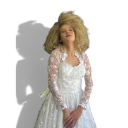 Noiva Dani Levine usando vestido branco 2 em 1 com renda floral, mangas longas transparentes e cauda elegante.