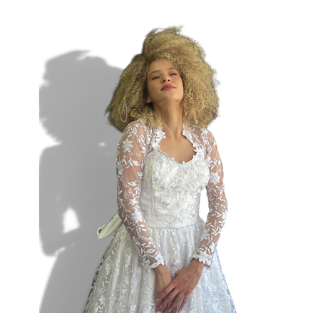 Noiva Dani Levine usando vestido branco 2 em 1 com renda floral, mangas longas transparentes e cauda elegante.